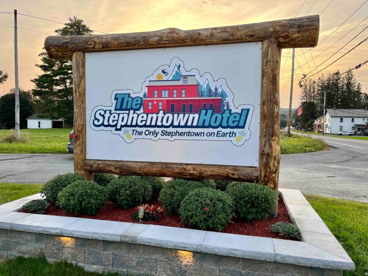 Une enseigne pour l’hôtel Stephentown, avec un logo représentant un bâtiment et des montagnes.