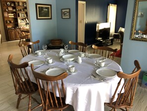A dining area with a round table set for six, surrounded by wooden chairs. - Four bedroom country home. (Kingsville)
