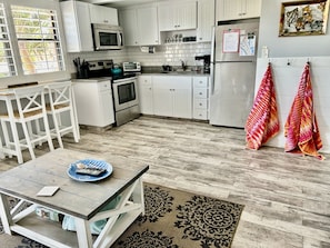 Kitchen area with microwave, oven, toaster, and dining table.
