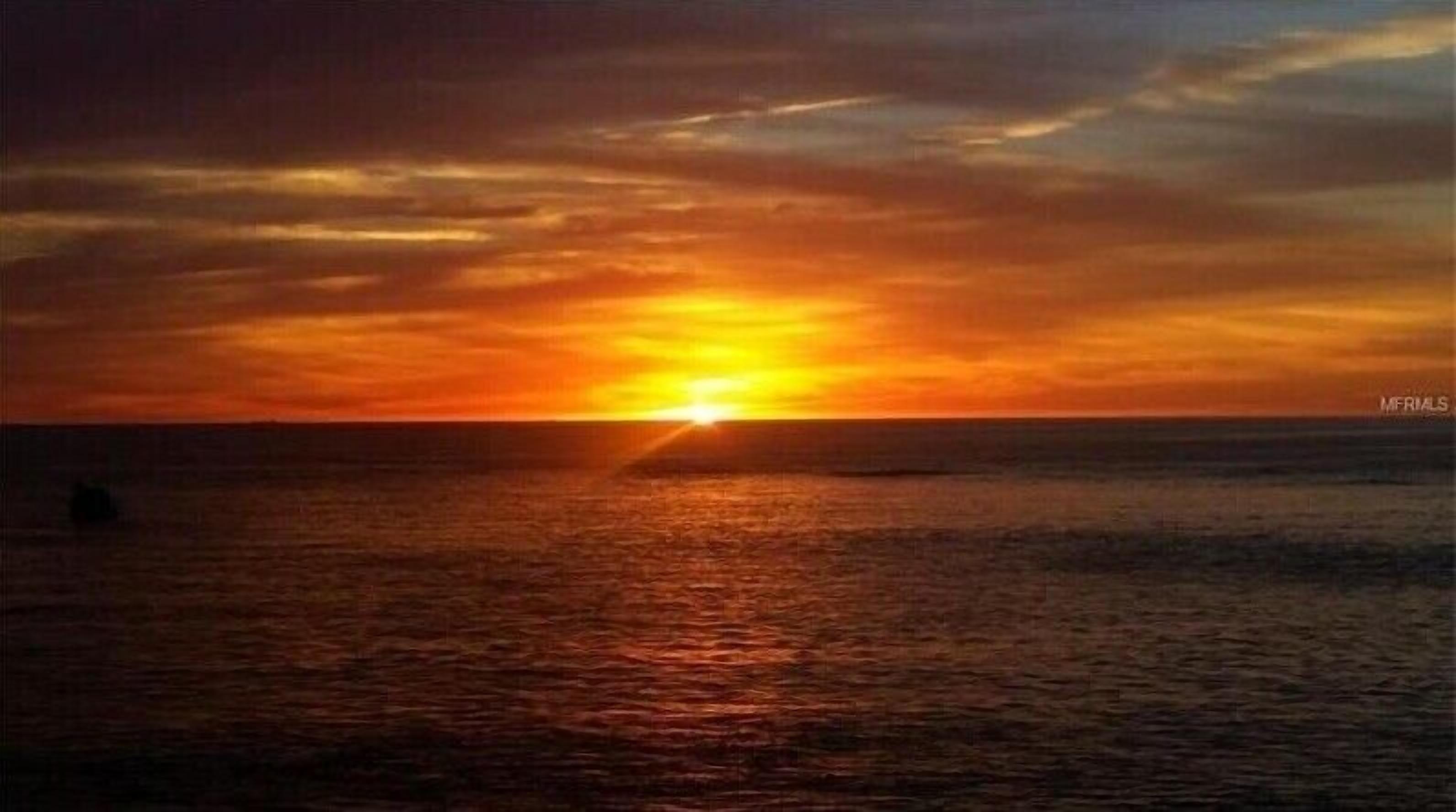 A sunset over the ocean with a clear horizon.