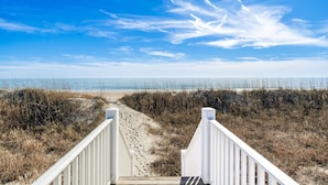 A wooden boardwalk leading to a beach with a clear sky. - Oceanfront stunner in Emerald Isle (Emerald Isle)