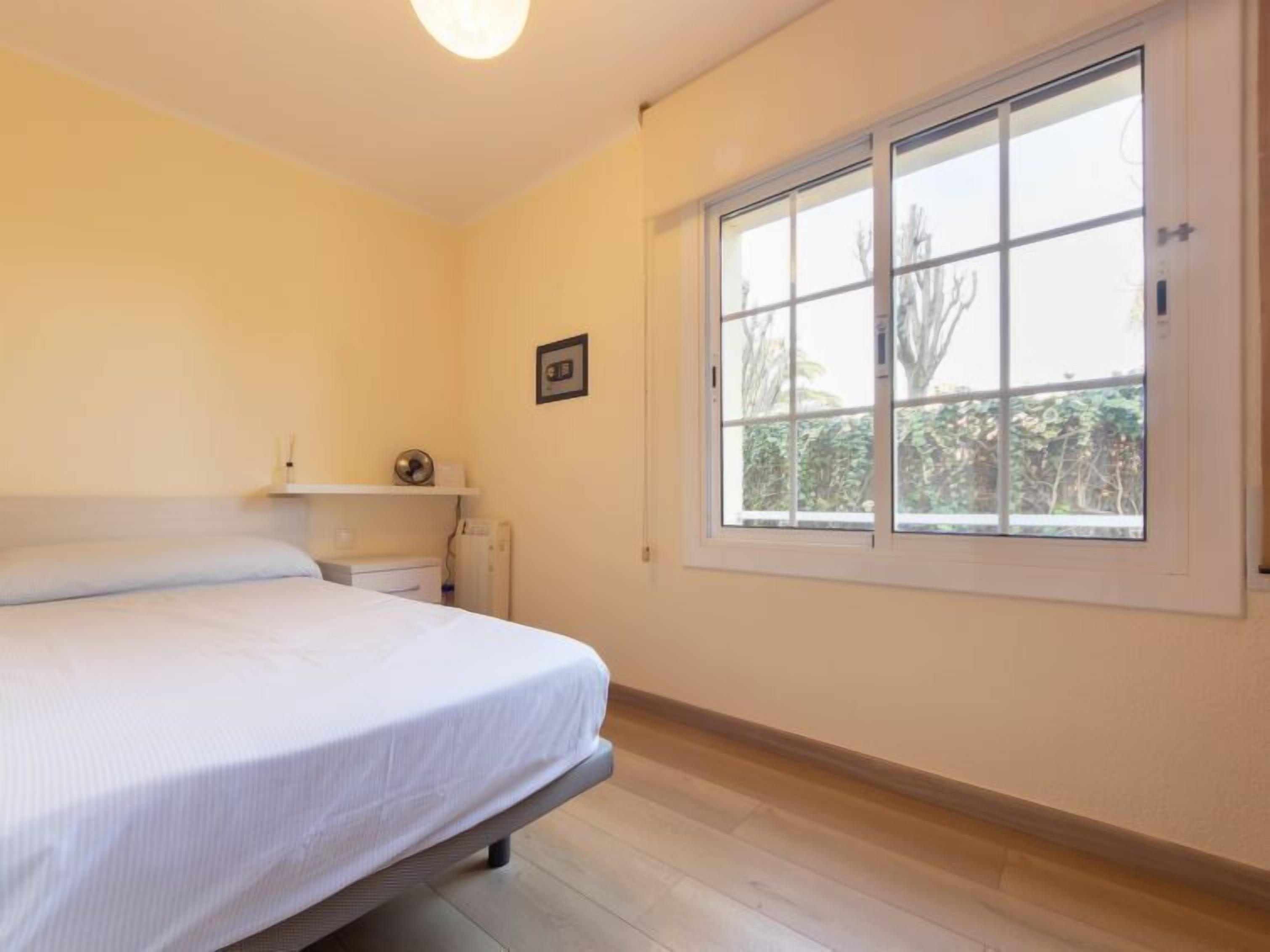 A bedroom with a bed, a window, and a radiator.