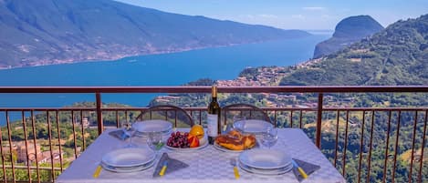 A table set for dining with a scenic lake view, surrounded by mountains.