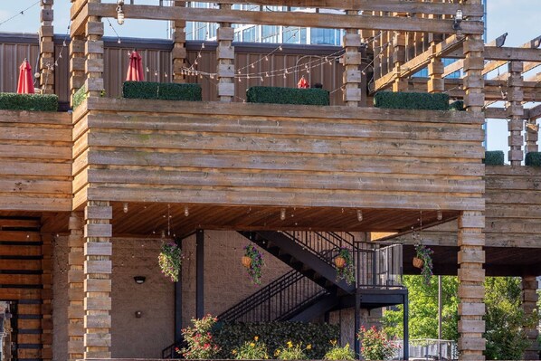 Une structure en bois dotée d’un escalier et de jardinières suspendues.