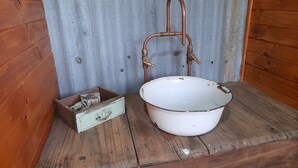 A rustic bathroom with a wooden sink and a small box of toiletries. - Experience a unique part of Australian History (Nagambie)