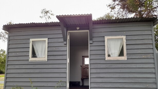 A small, single-story wooden cabin with a porch, a door leading inside, and a small set of steps. - Experience a unique part of Australian History (Nagambie)