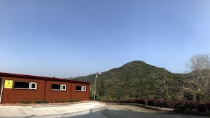 A red building with a sign indicating it is number 5 and a contact number. - North Mountain Farm (Puli)