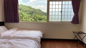 A bedroom with a bed, a window with curtains, and a wooden floor. - North Mountain Farm (Puli)