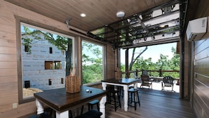 A wooden interior with a large window, a table, and chairs. - Hibernation Hideaway - Private indoor pool, theater room, hot tub, games, and more! (Pigeon Forge)