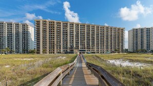 A modern high-rise hotel with a central walkway leading to the entrance. - Extra Large Balcony Phoenix VII 3/2 Flash Sale (Orange Beach)