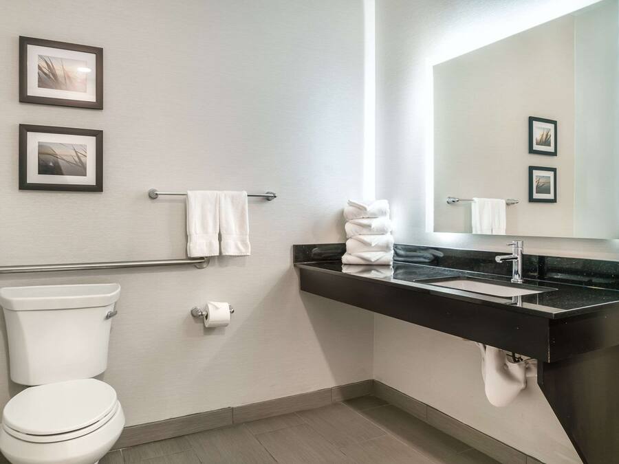 A modern bathroom with a toilet, sink, and towel rack.