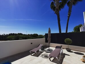 A rooftop terrace with two sun loungers, a small table, and a potted plant. - Magnificent villa in Orihuela Costa close to everything with heated pool* (Orihuela)
