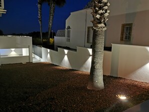 A nighttime view of a building with white walls and a gravel ground. - Magnificent villa in Orihuela Costa close to everything with heated pool* (Orihuela)