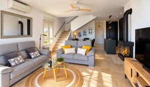 A modern living room with a sofa, a glass coffee table, and a fireplace. - Magnificent villa in Orihuela Costa close to everything with heated pool* (Orihuela)
