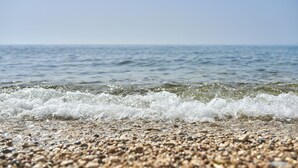 Ein Strand mit Kieselsteinen und Wellen.