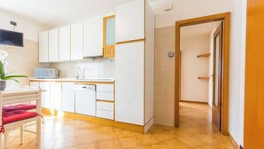 A kitchen with white cabinets, a microwave, and a dishwasher. - Family-Friendly Apartment Near Terme Comano (Ponte Arche)