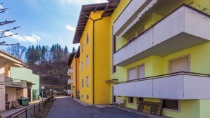 A street view with yellow and white buildings, a clear sky, and a road leading into the distance. - Family-Friendly Apartment Near Terme Comano (Ponte Arche)