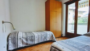 Une chambre à coucher avec un lit, une armoire, une fenêtre et un radiateur.