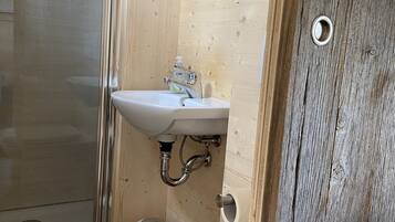 Un baño con un lavamanos blanco, inodoro y ducha.