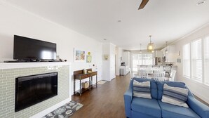 A modern living room with a fireplace, a television, and a blue sofa.