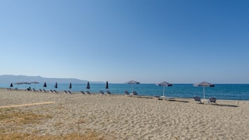 En la playa, camastros, sombrillas y bar en la playa