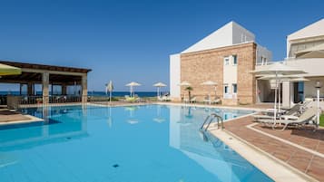 Una piscina al aire libre de temporada, sombrillas