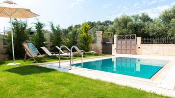 Relax by the pool surrounded by lush greenery and a secure fence.