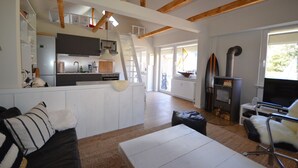 Ein geräumiger Wohnbereich mit Küche, Kamin und einer Couch.