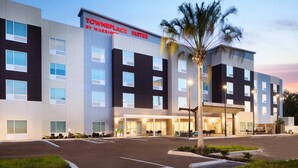 Un hôtel moderne avec une enseigne indiquant « TownePlace Suites by Marriott » et un espace d’entrée abrité.