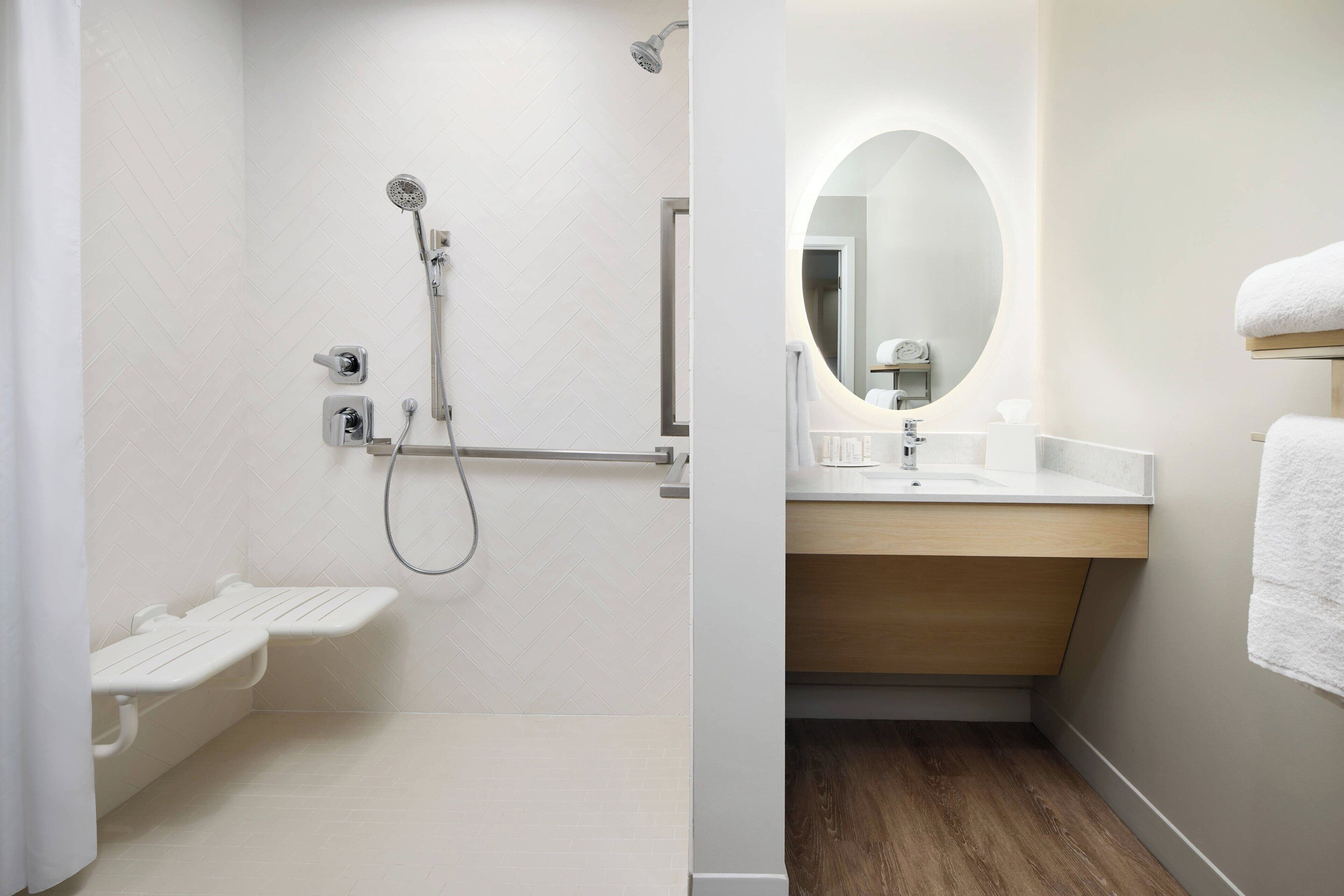 Een badkamer met douche, toilet en wastafel, inclusief spiegel en handdoekhouder.