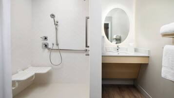 Een badkamer met douche, toilet en wastafel, inclusief spiegel en handdoekhouder.