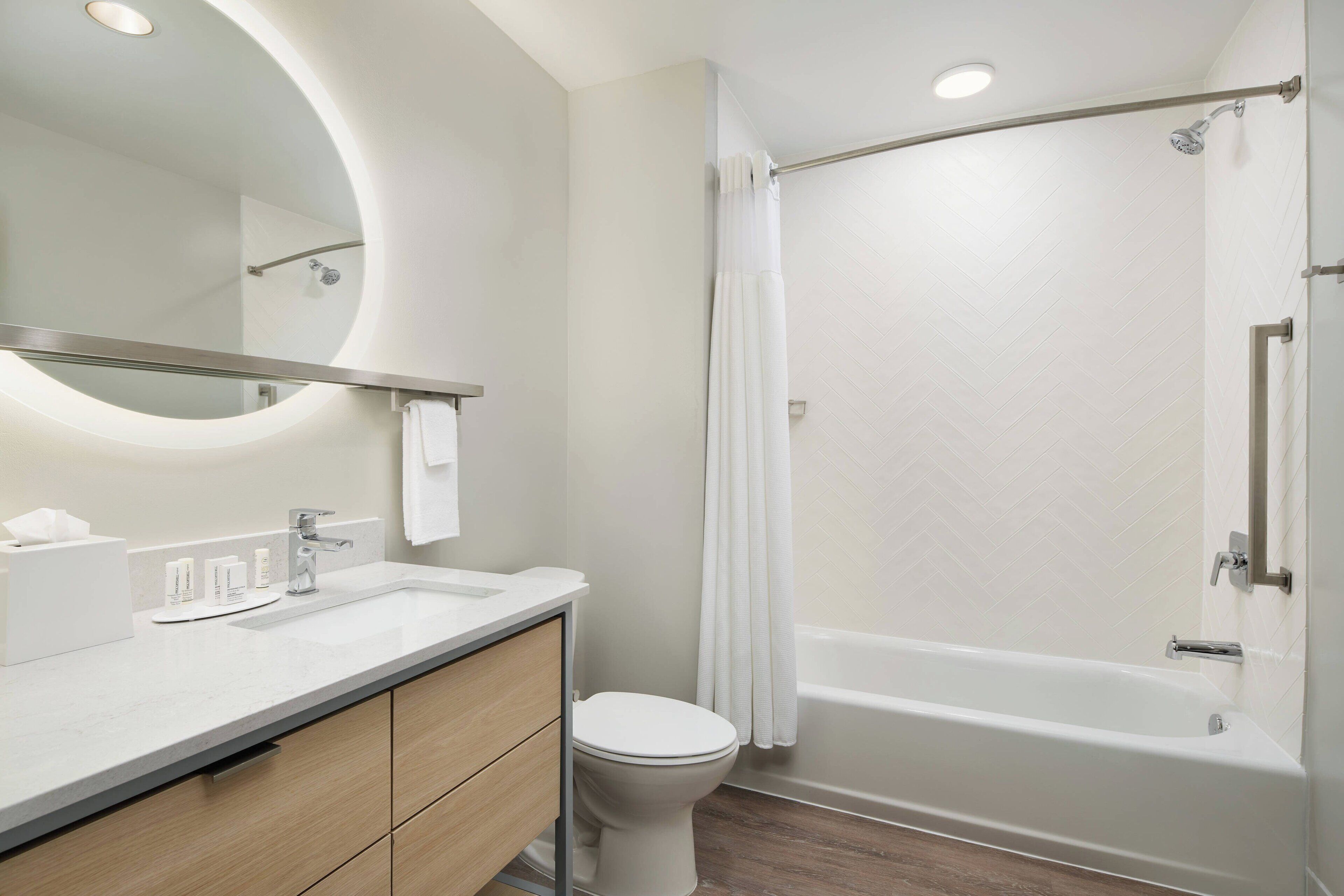 A modern bathroom with a sink, toilet, and bathtub.