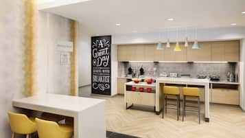 Cocina moderna con una isla central, taburetes de bar e iluminación colgante.