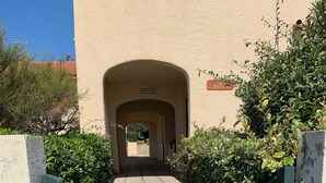 A gated entrance with a concrete pathway leading to a covered archway. - MAGNIFICENT SEA VIEW 🌊  (Sausset-les-Pins)