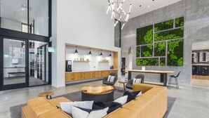 Un interior moderno con una zona de estar, una cocina y un ventanal con vegetación.