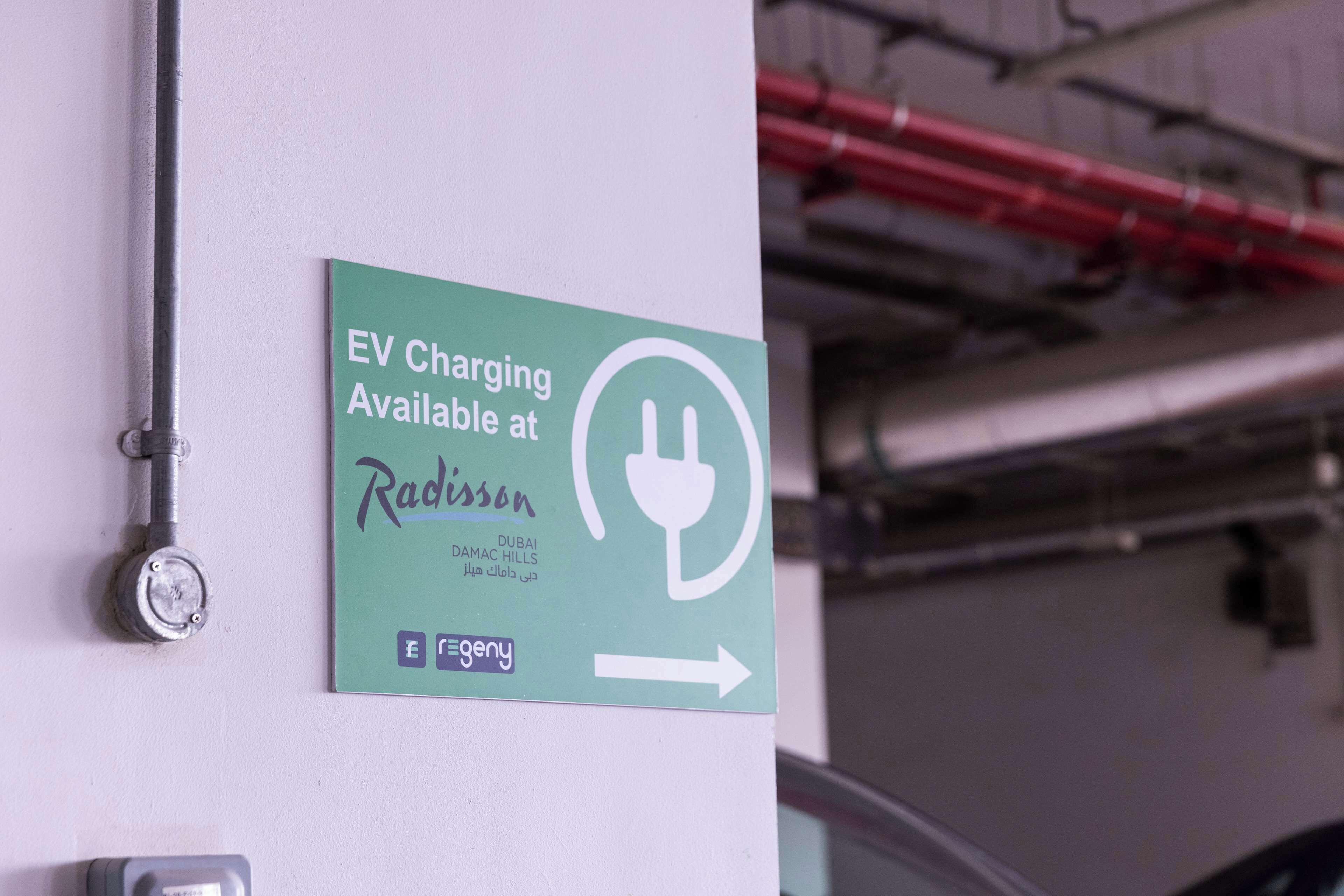 Un panneau indiquant la présence de bornes de recharge pour véhicules électriques à l’hôtel Radisson de Dubaï.