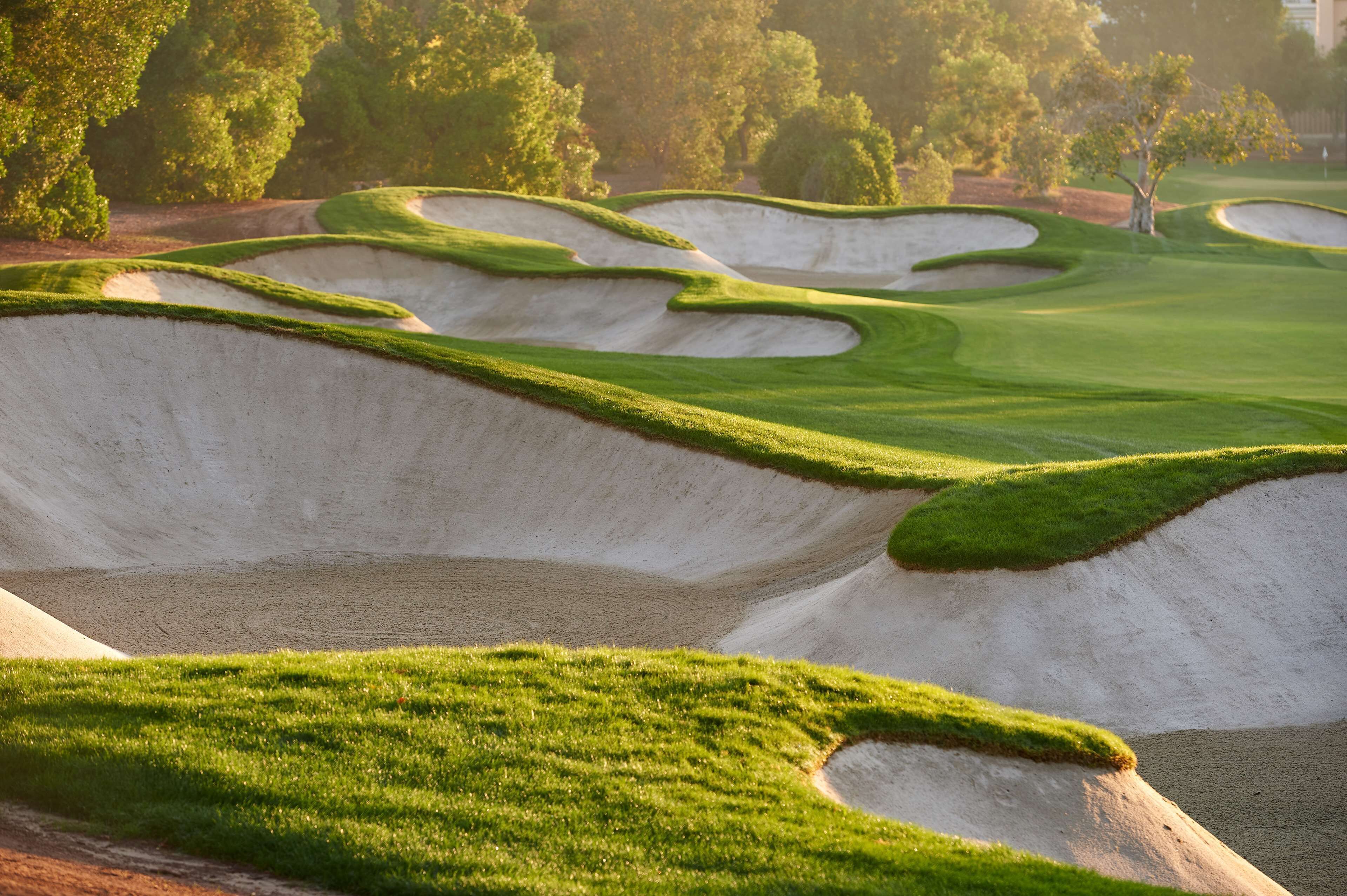 Un parcours de golf doté de bunkers de sable et d’une pelouse bien entretenue.