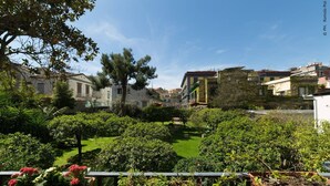 A courtyard with lush greenery, a small pond, and buildings with balconies. - THE BELLINI HOUSE (Naples)