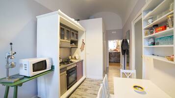 A compact kitchen with a microwave, stove, and cabinets.
