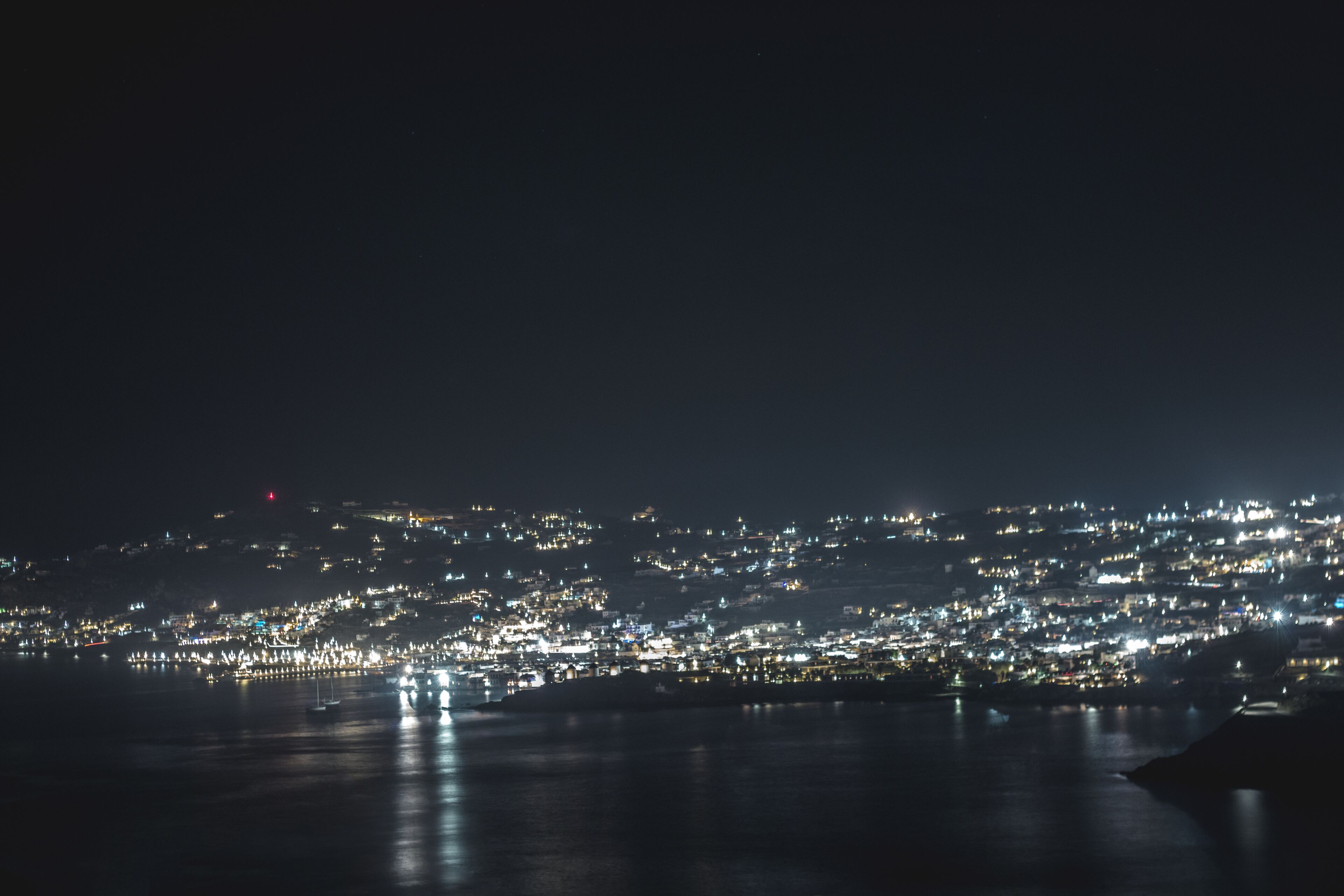 A nighttime cityscape with a waterfront.