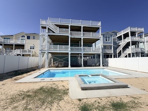 A multi-story building with a pool area, including a hot tub and a standard pool.