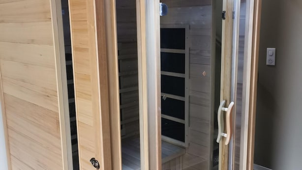Un meuble en bois doté de portes en verre et d’une poignée en métal.