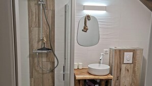 Une salle de bain moderne avec une douche à parois de verre, un meuble-lavabo en bois et des toilettes.