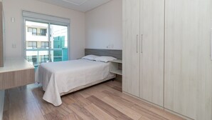 A bedroom with a bed, a desk, and a wardrobe. - Zancanaro Apto 202  641D (Bombinhas)