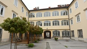 A courtyard with a building featuring multiple windows and a central entrance. - Atik Rooms (Ljubljana)
