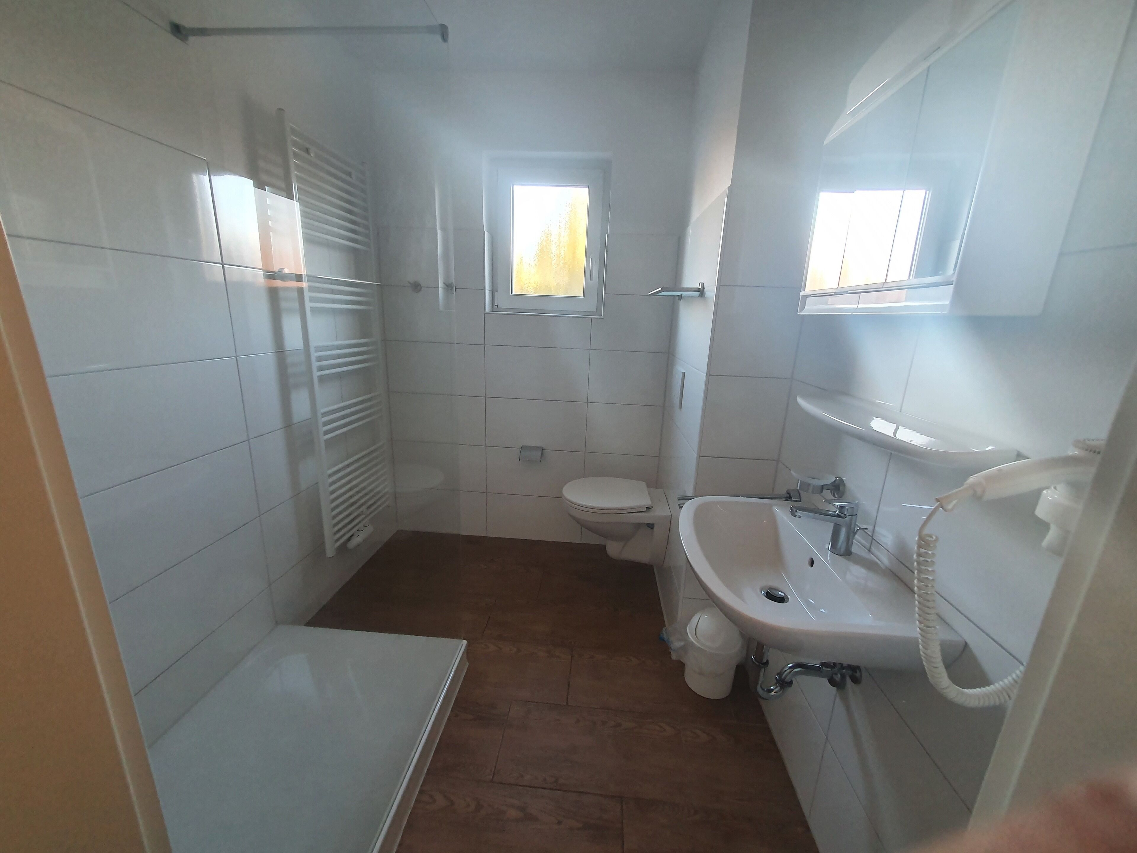Un baño pequeño con azulejos, un inodoro, lavamanos y ducha.
