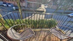 A balcony with two wicker chairs and a metal railing. - Krabbenkieker (Norden)