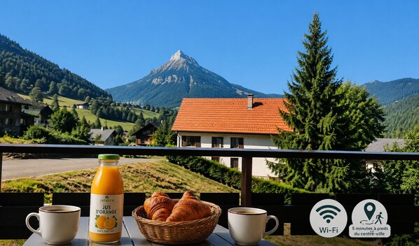 A balcony with breakfast items, a mountain view, and Wi-Fi availability.