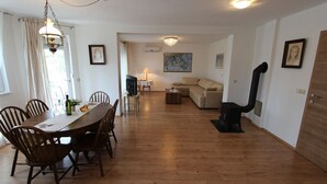 Un coin repas avec une table et des chaises en bois, un canapé, une cheminée et un téléviseur dans le salon.