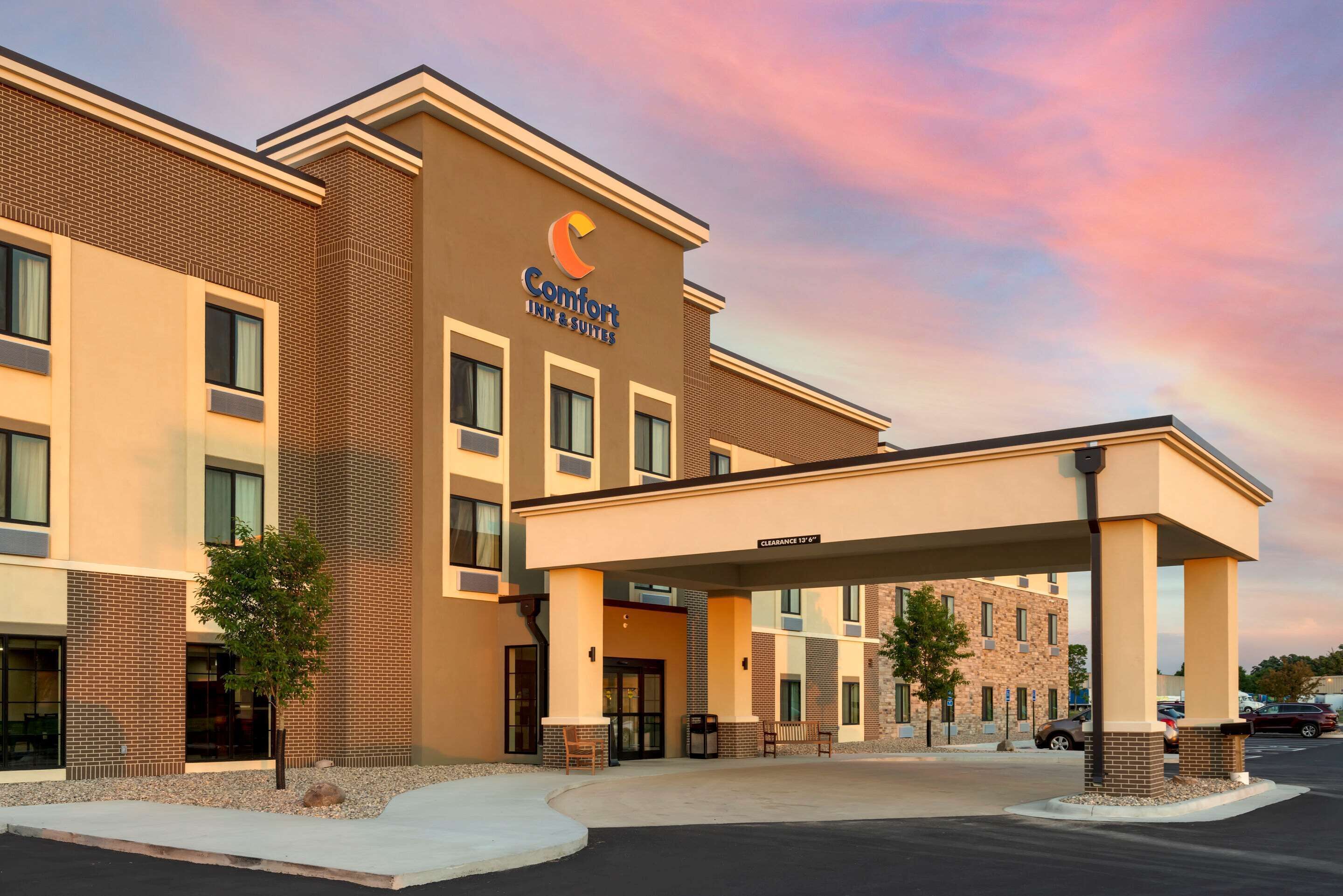 A Comfort Inn & Suites building with a brick facade, multiple windows, and a covered entrance area.